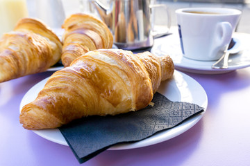 Breakfast with coffee and croissants on table