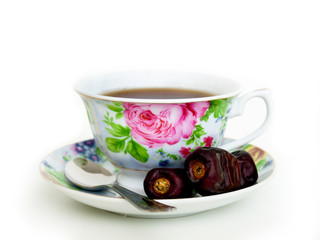 Dried dates and  cup of black tea. Isolated on white background
