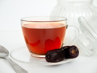 Dried dates and  cup of black tea. Isolated on white background