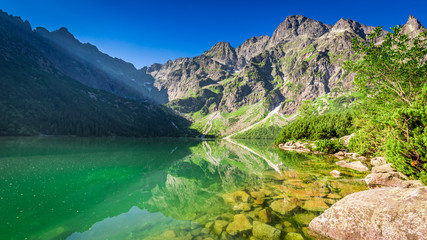Fototapeta na wymiar Stunning pond in the mountains at sunrise in summer