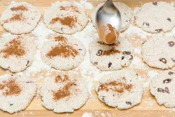 Biscuits with cinnamon, cottage cheese and raisins on the wooden board in the kitchen. Homemade pastries. Christmas tradition baking cookies, cakes and biscuits. Very tasty.