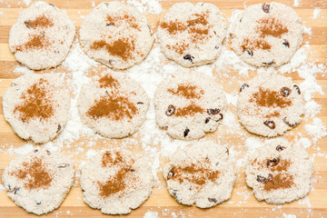 Biscuits with cinnamon, cottage cheese and raisins on the wooden board in the kitchen. Homemade pastries. Christmas tradition baking cookies, cakes and biscuits. Very tasty.
