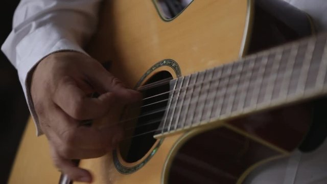 Male musician playing the guitar. Close-up of hands.