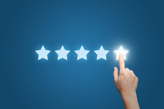 Businesswoman pointing five star to increase