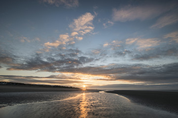 Fototapeta na wymiar Beautiful beach coastal low tide landscape image at sunrise with