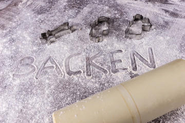 Baking Backen in German letters written in flour on the table