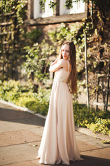 Attractive young woman with long dress enjoying her time outside in park sunset background