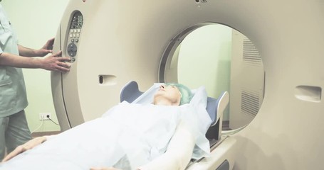 Female patient on CT MRI scanner 4k video. woman moving on computed tomography in diagnostic clinic after test - Powered by Adobe