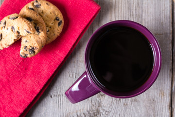 Cup of coffee and biscuits red napkin on grey wooden table