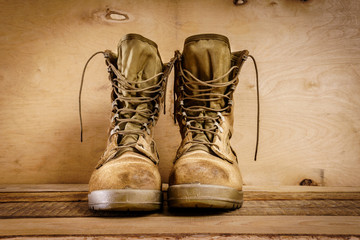old brown military boots on a wooden table