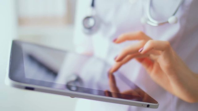 Close-up of hands of the young nurse working with the tablet