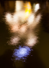 Reflection of light at night in water in the form of people