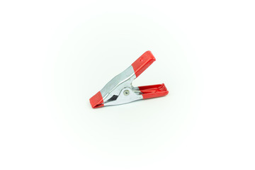 Metal spring clamp with red plastic isolated on white