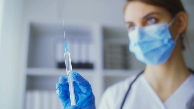 The young nurse checked medicine in a syringe