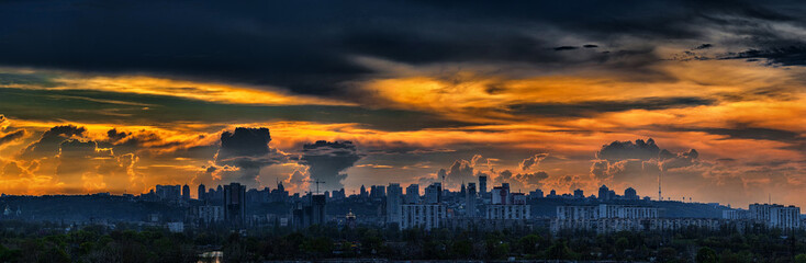 Fototapeta premium Panoramic view of the big city silhouette against the backdrop of incredibly, awesome bright, colored sunset. Kyiv. Ukraine.