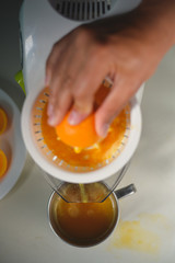 Closeup on hand of a person squeezing healthy orange juice mix
