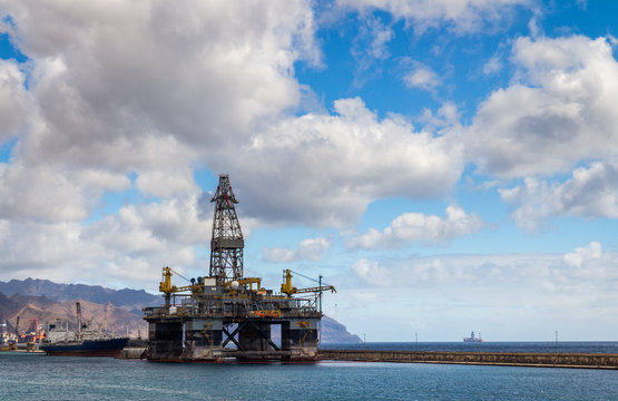 Image of oil platform with clouds and sky.