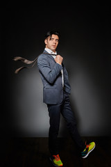 A young guy in a suit and bright yellow sneakers.
