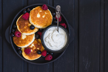 cheese pancakes with berries and yoghurt for breakfast  