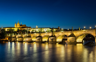 Fototapeta premium Pargue at dusk, view of the Lesser Bridge Tower of Charles Bridge (Karluv Most) and Prague Castle, Czech Republic.