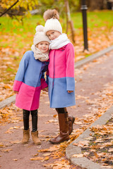 Fototapeta premium Little adorable girls outdoors at warm sunny autumn day