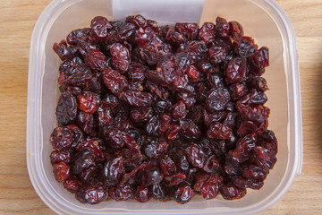 Transparent plastic bowl full of dried blueberry