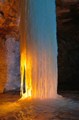 Ice column illuminated by candles inside the marble mine.Ruskeala, Karelia, Russia.