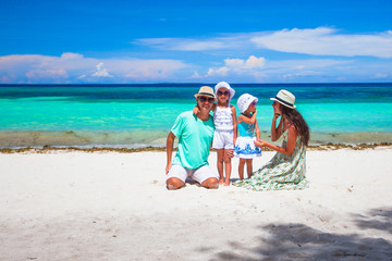 Fototapeta premium Happy beautiful family with kids walking together on tropical beach during summer vacation