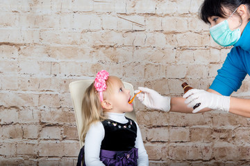 Mother giving her daughter syrup dose of cough. Treatment of colds and flu.