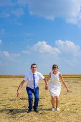 Happy young newlywed couple on a field