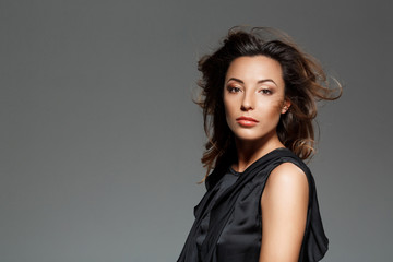 Fototapeta premium Young beautiful woman looking at camera over grey background.
