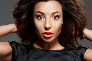 Fototapeta premium Young beautiful woman looking at camera over grey background.