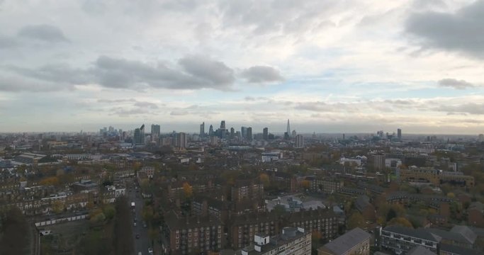 Aerial push out view of a typical village in North London with the skyline of London in the background