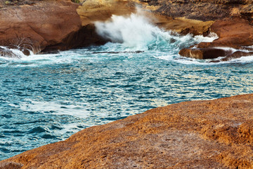 view of the sea and waves crashing on the rocks