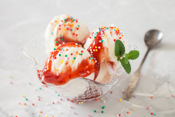 ice cream with strawberry syrup in an ice-cream bowl on a table, selective focus