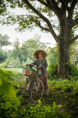 Happy Asian elderly seniors couple biking in the nature