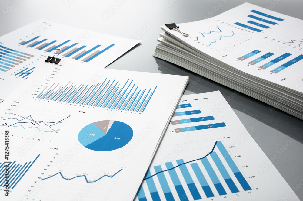 Poster Prepareing report. Blue graphs and charts.
Business reports and pile of documents on gray reflection background.
