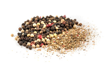 Mixed peppercorns and ground pepper isolated on white background