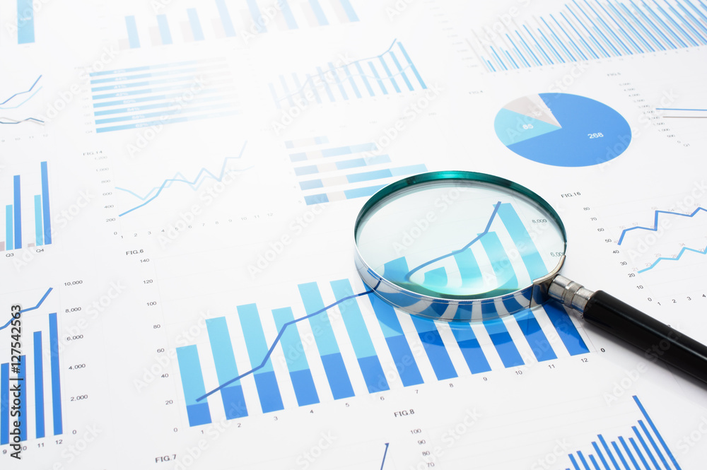 Poster Many charts and magnifying glass. Reviewing data.　Financial reports and magnifying glass. Reflection background.
