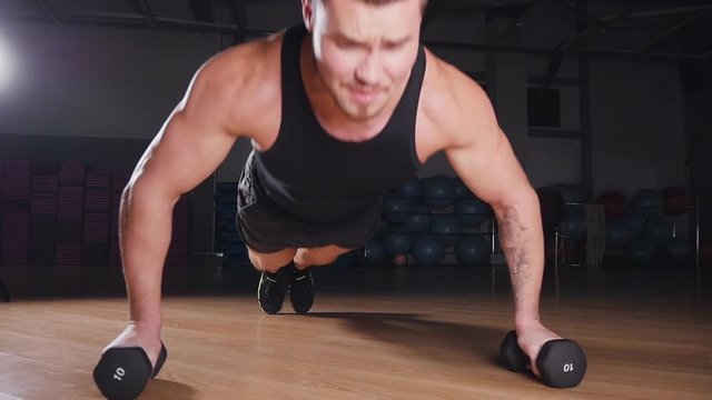 Young muscular athlete doing pushups