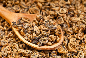 Green tea leaves braided in balls/ Braided yunnan black tea/ tea leaves background