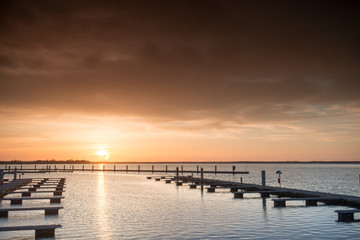 Fototapeta premium Yacht port over orange sunset