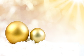 Gold Snowball on snow field in yellow blurred background with ra