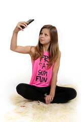 Śliczna dziewczyna, nastolatka robi sobie selfie na białym tle. - obrazy, fototapety, plakaty