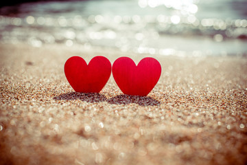 Fototapeta premium romantic symbol of two hearts on the beach 