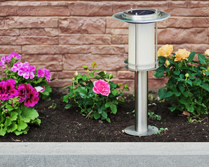 Solar-powered lamp on garden background. Selective focus.