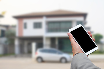 Hand holding smart phone at home blured background.