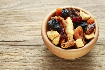 Bowl of dried fruits on wood