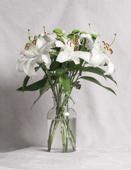 Lilies and green chrysanthemums in glass vase
