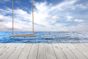 wooden swing and wood floor on sea wave in blue sky background.